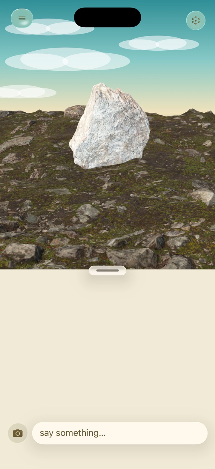 A rock on a patch of tundra under a blue sky